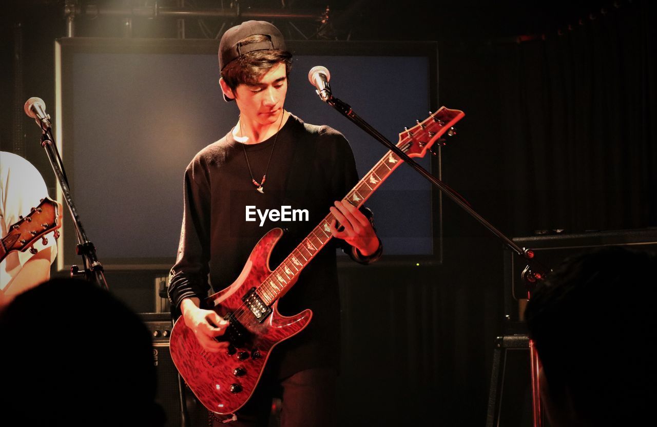 Full length of young man playing electric guitar