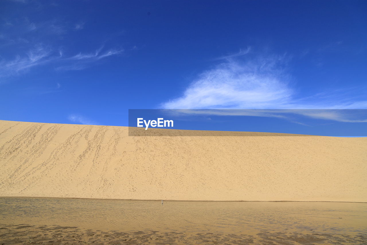 SCENIC VIEW OF SAND DUNE AGAINST SKY