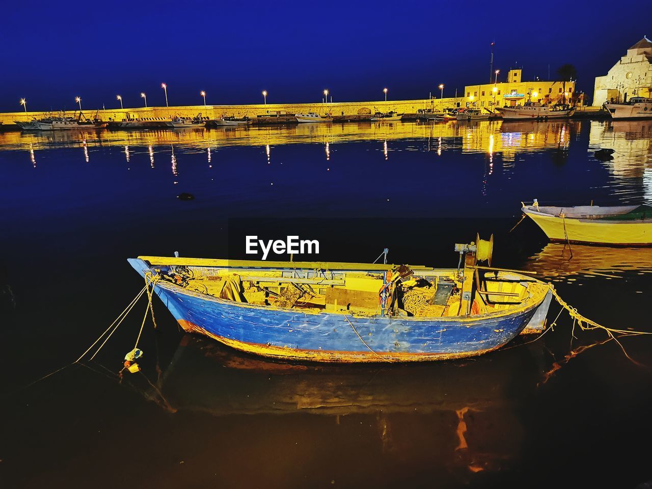 BOATS MOORED IN RIVER AGAINST SKY