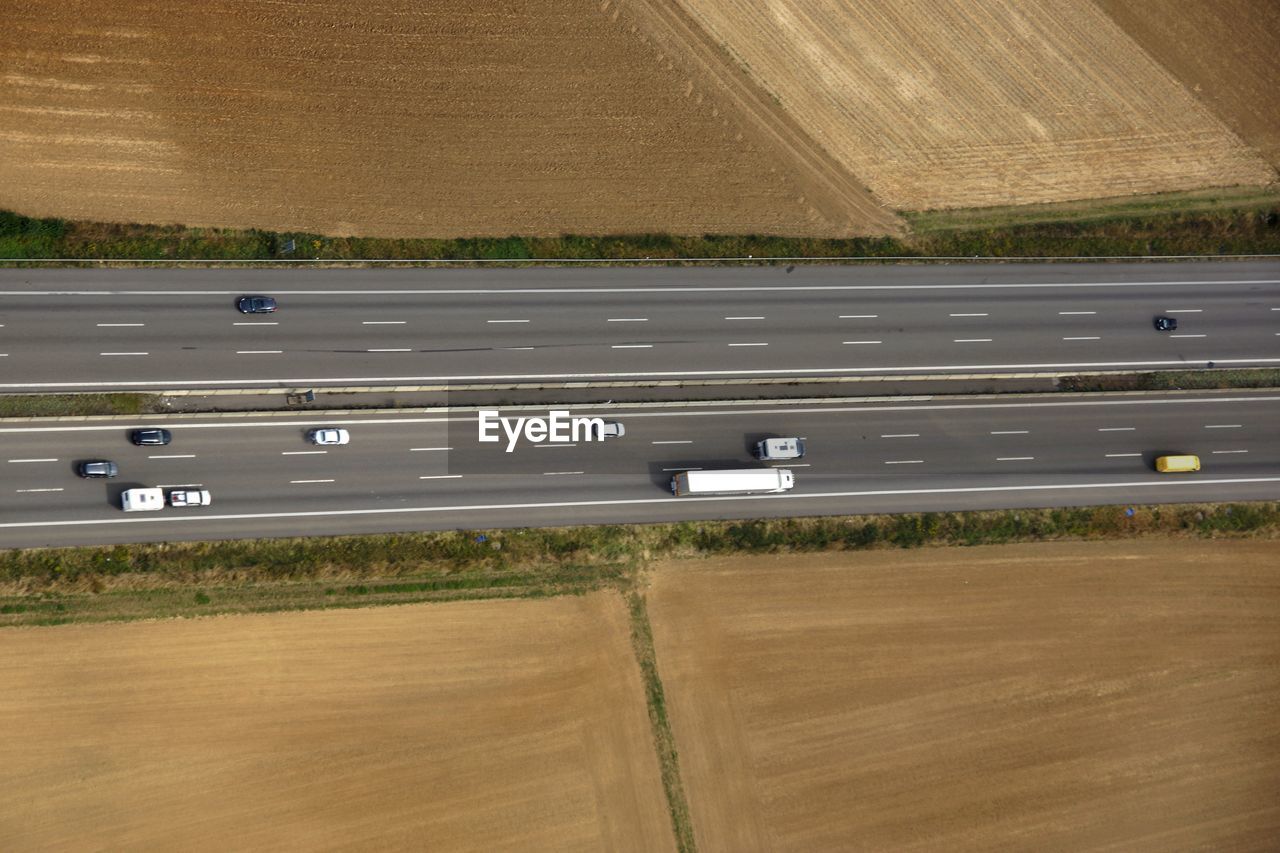 Aerial view of vehicles on road amidst agricultural field