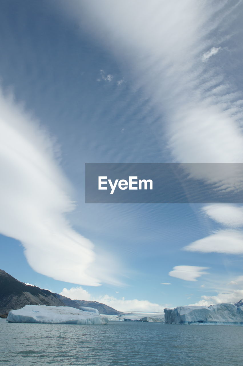 SCENIC VIEW OF SEA BY MOUNTAINS AGAINST SKY