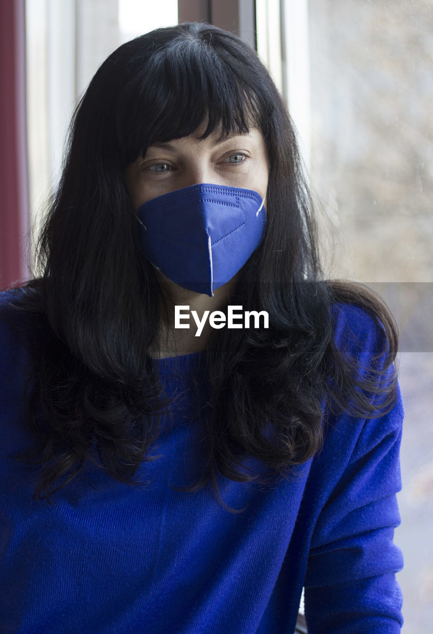 Portrait of a woman with blue protective face mask