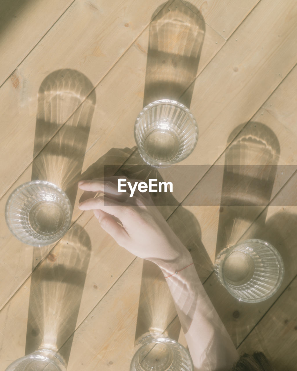 High angle view of hand with glass on table