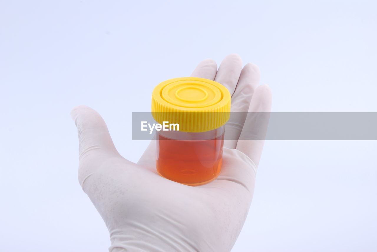 CLOSE-UP OF PERSON HAND HOLDING WHITE BACKGROUND