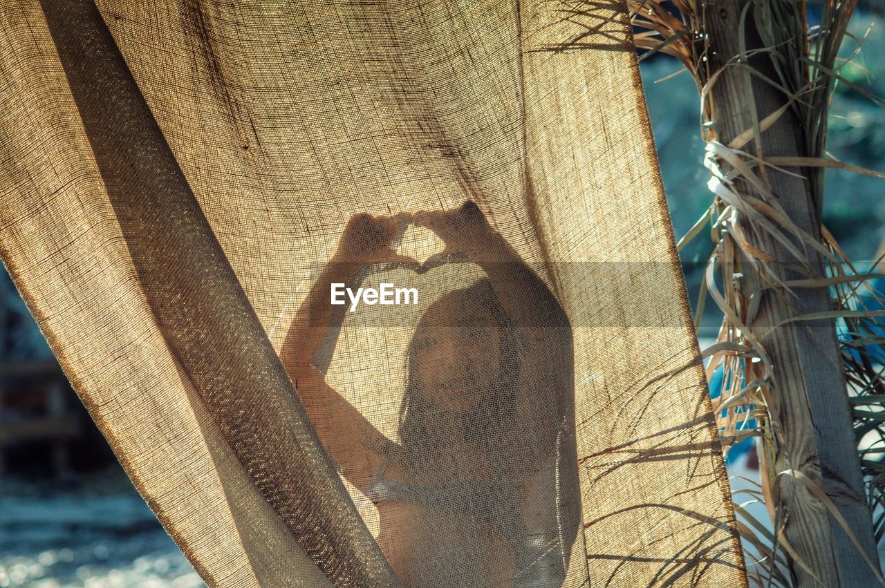 Close-up girl behind curtain on beach