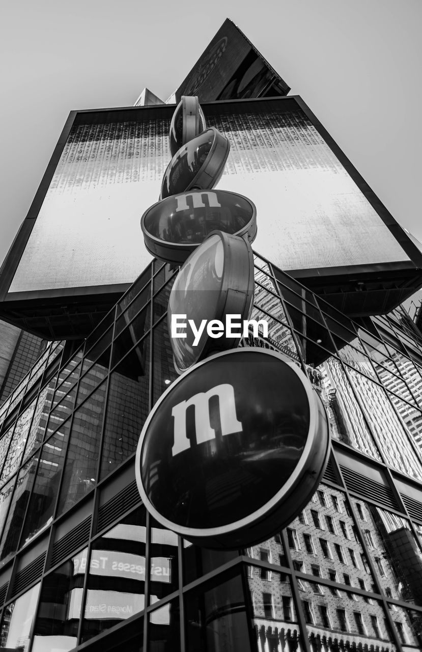 LOW ANGLE VIEW OF ROAD SIGN AGAINST BUILDINGS