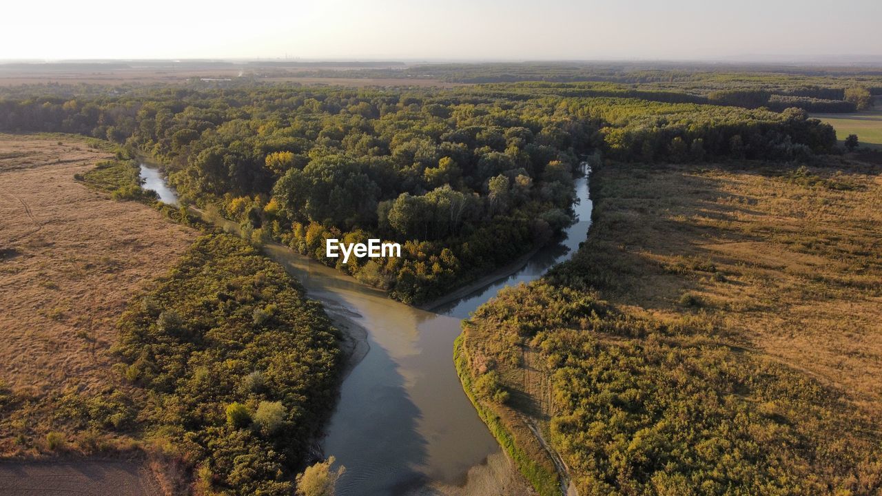 HIGH ANGLE VIEW OF RIVER FLOWING THROUGH LANDSCAPE