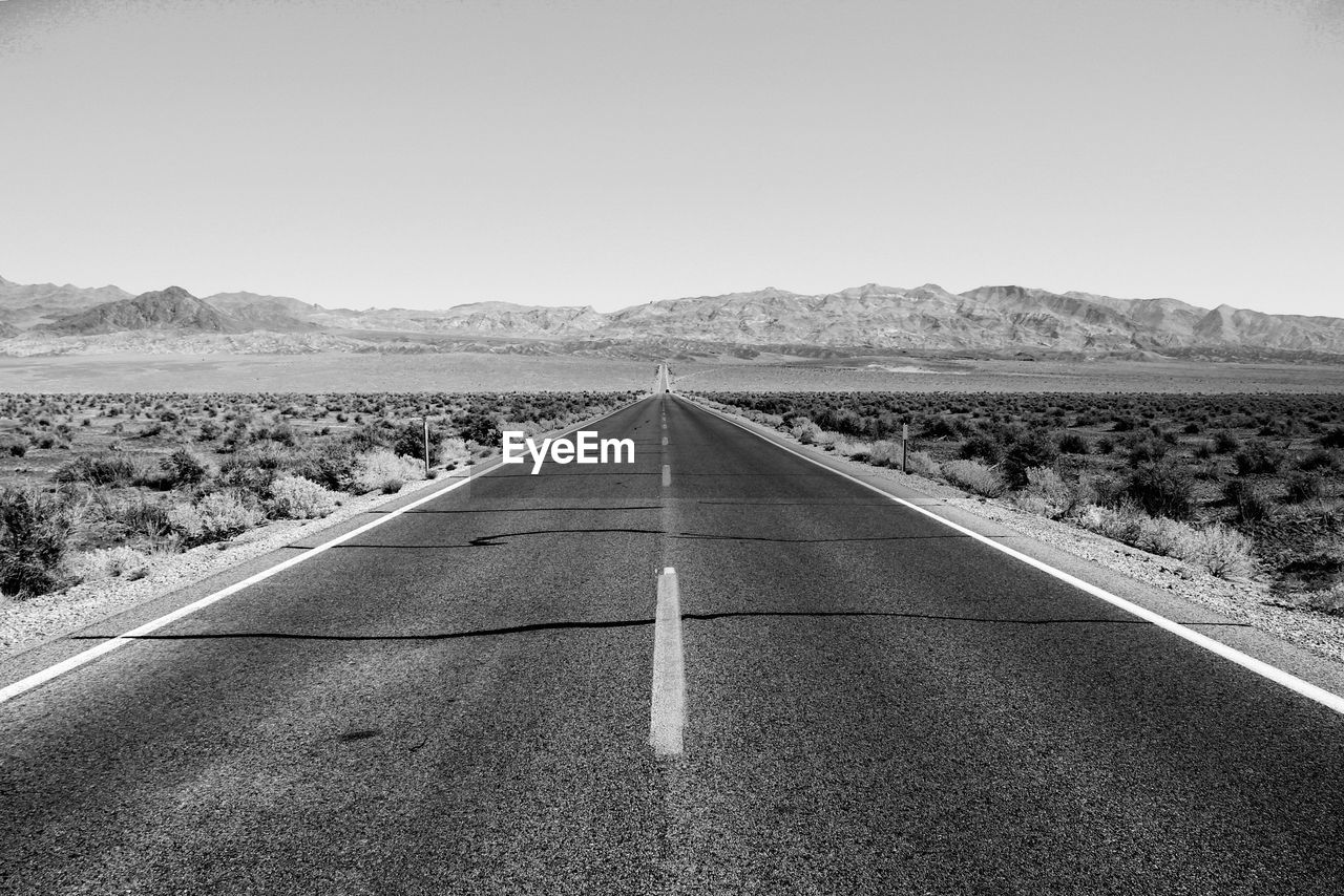 Empty road on landscape against clear sky