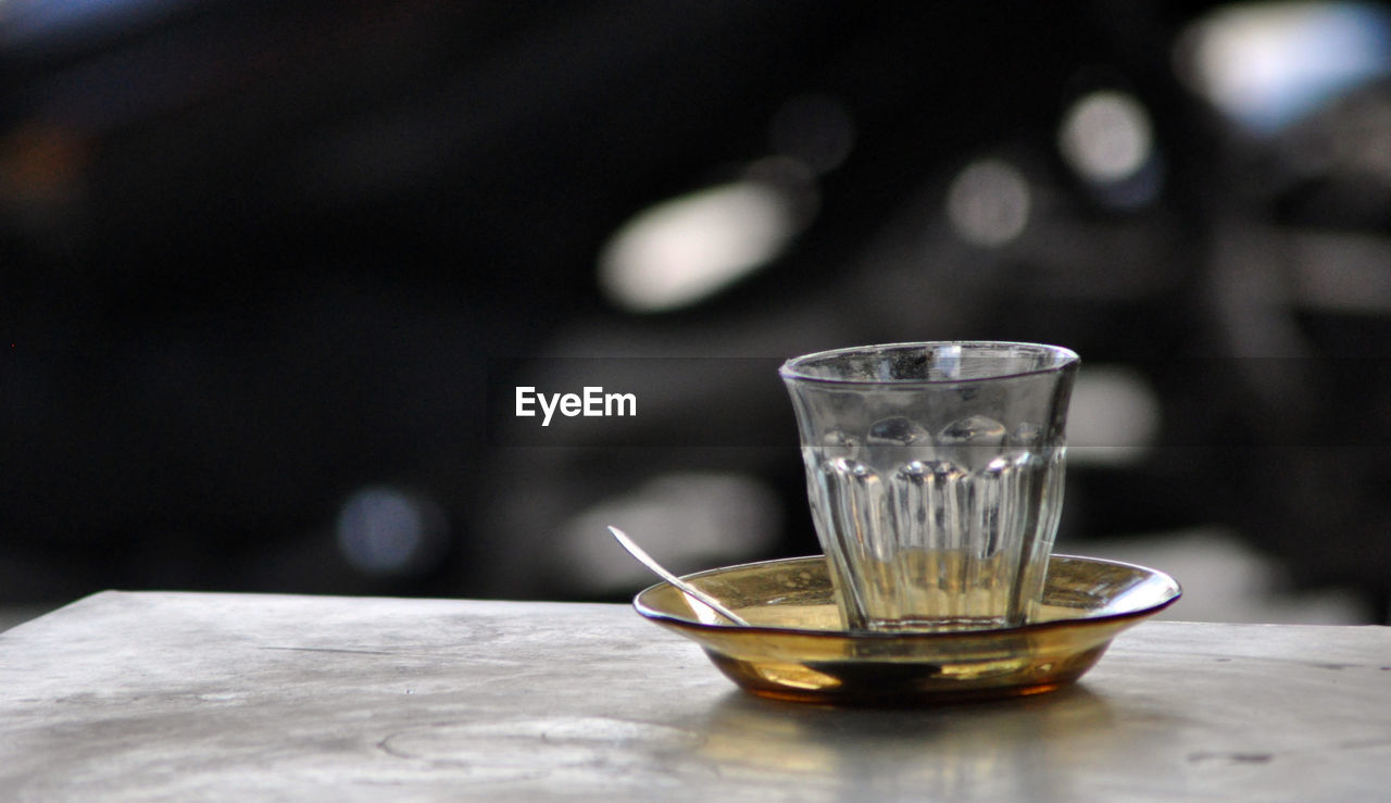 Close-up of glass and saucer on table