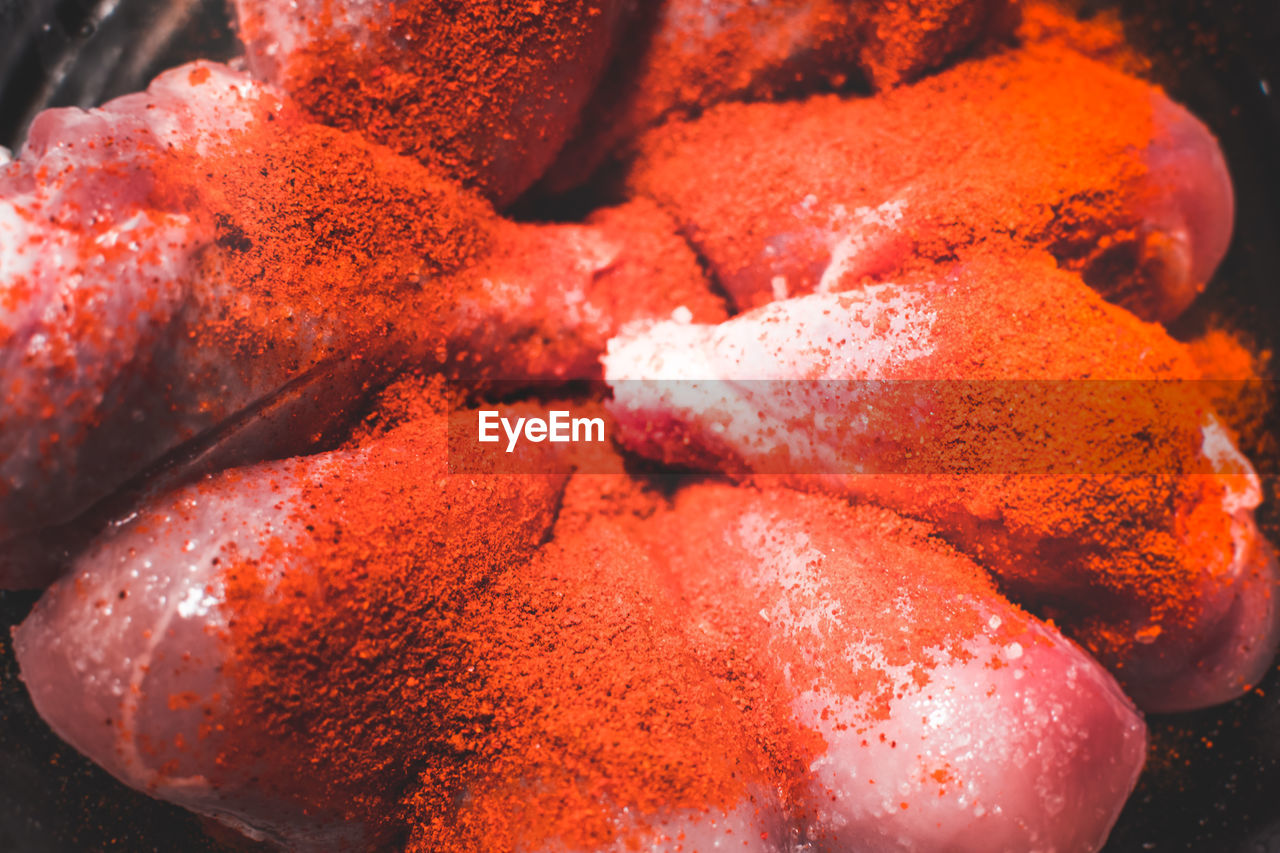 Close-up of red chili powder on meat