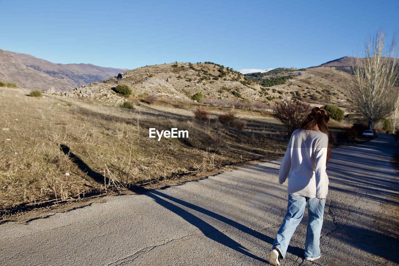 Rear view of man on road against mountain