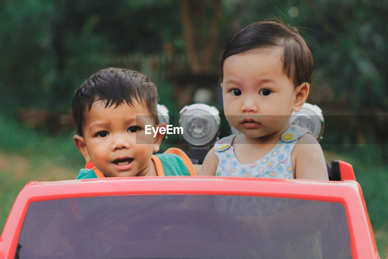 Siblings in toy car