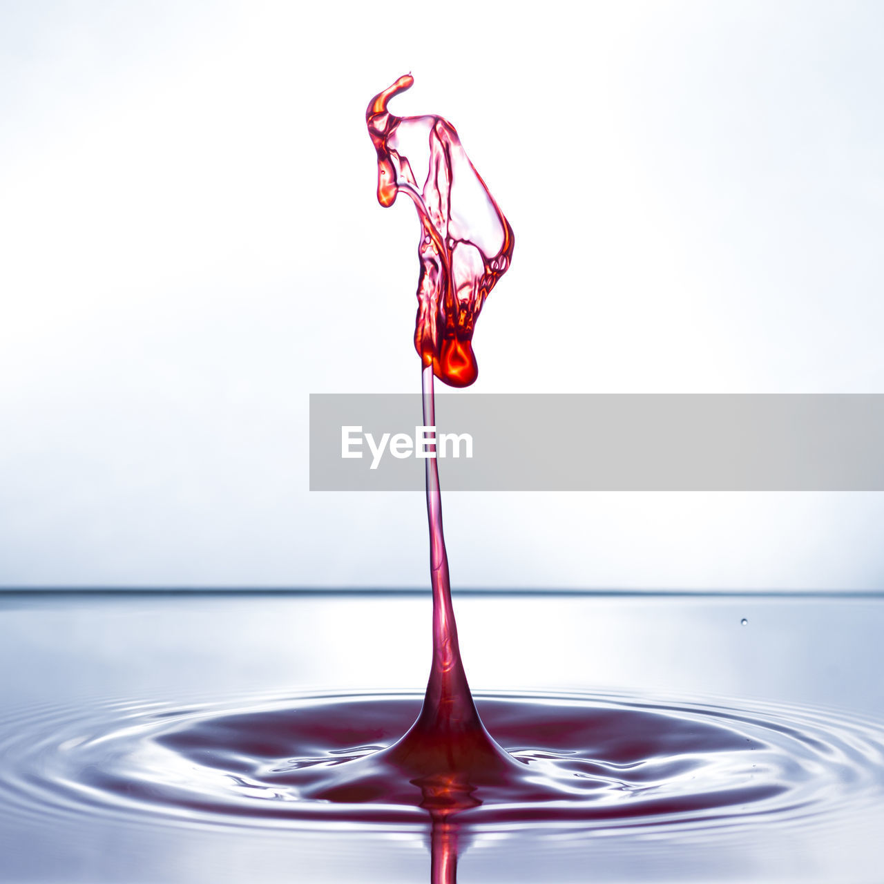 CLOSE-UP OF WATER DROPS ON RED CONTAINER