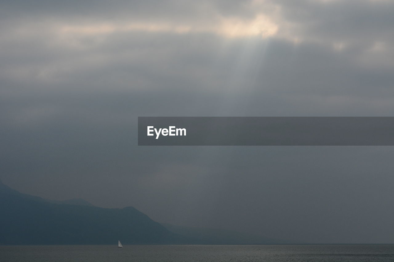 SCENIC VIEW OF SEA AND MOUNTAIN AGAINST SKY