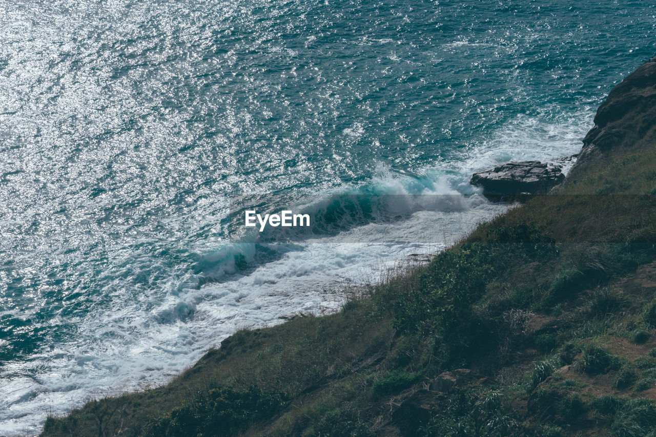 HIGH ANGLE VIEW OF WAVES ON SHORE