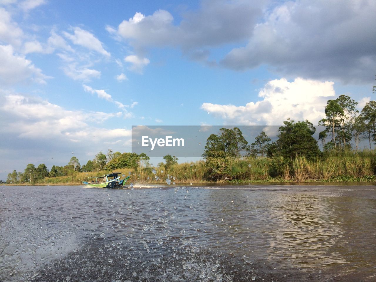 RIVER AMIDST TREES AGAINST SKY