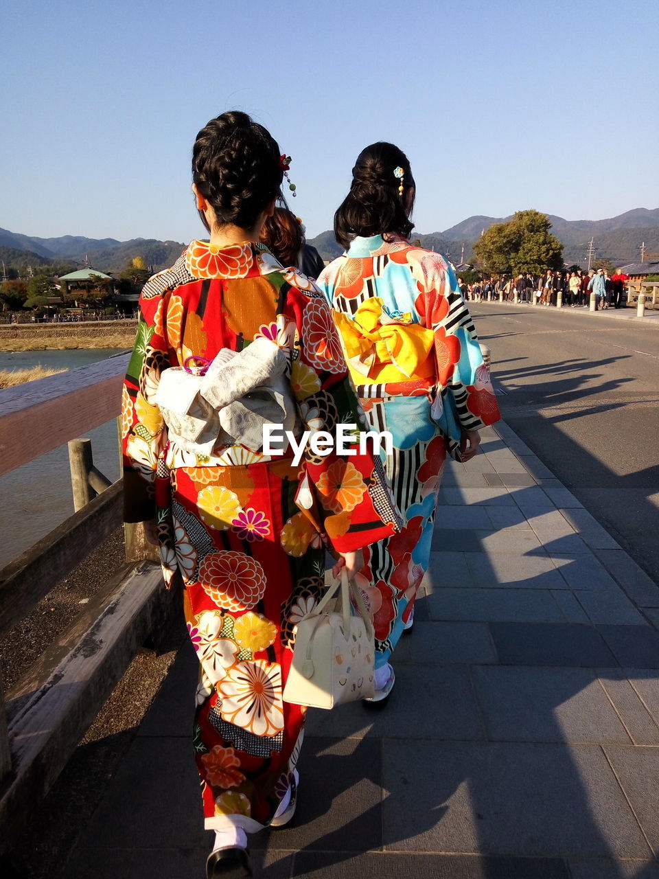 Women in traditional clothing walking on sidewalk in city