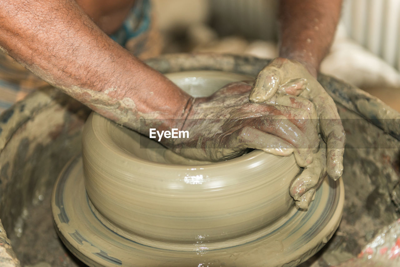 Cropped image of hands making pottery