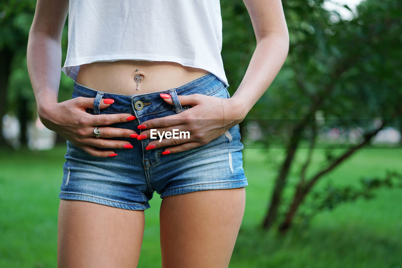 Midsection of woman wearing hot pants while standing at park