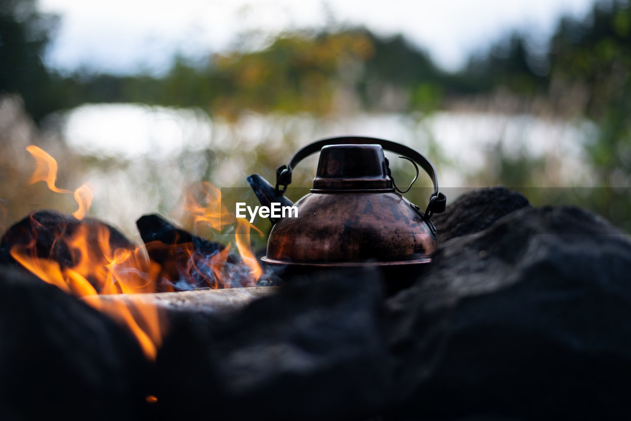 Close-up of kettle by rocks