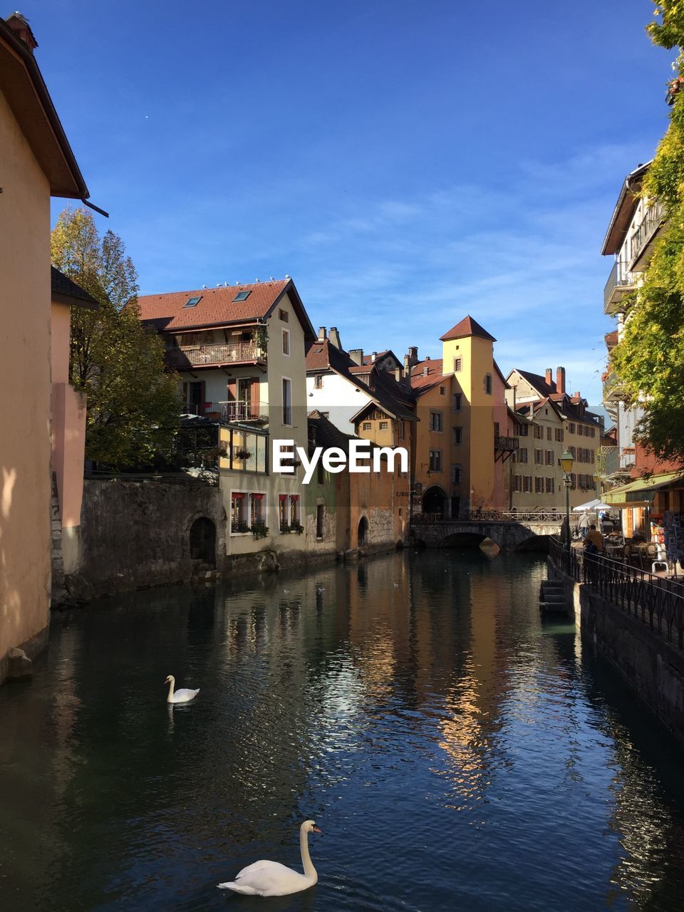 Buildings by river against sky in city