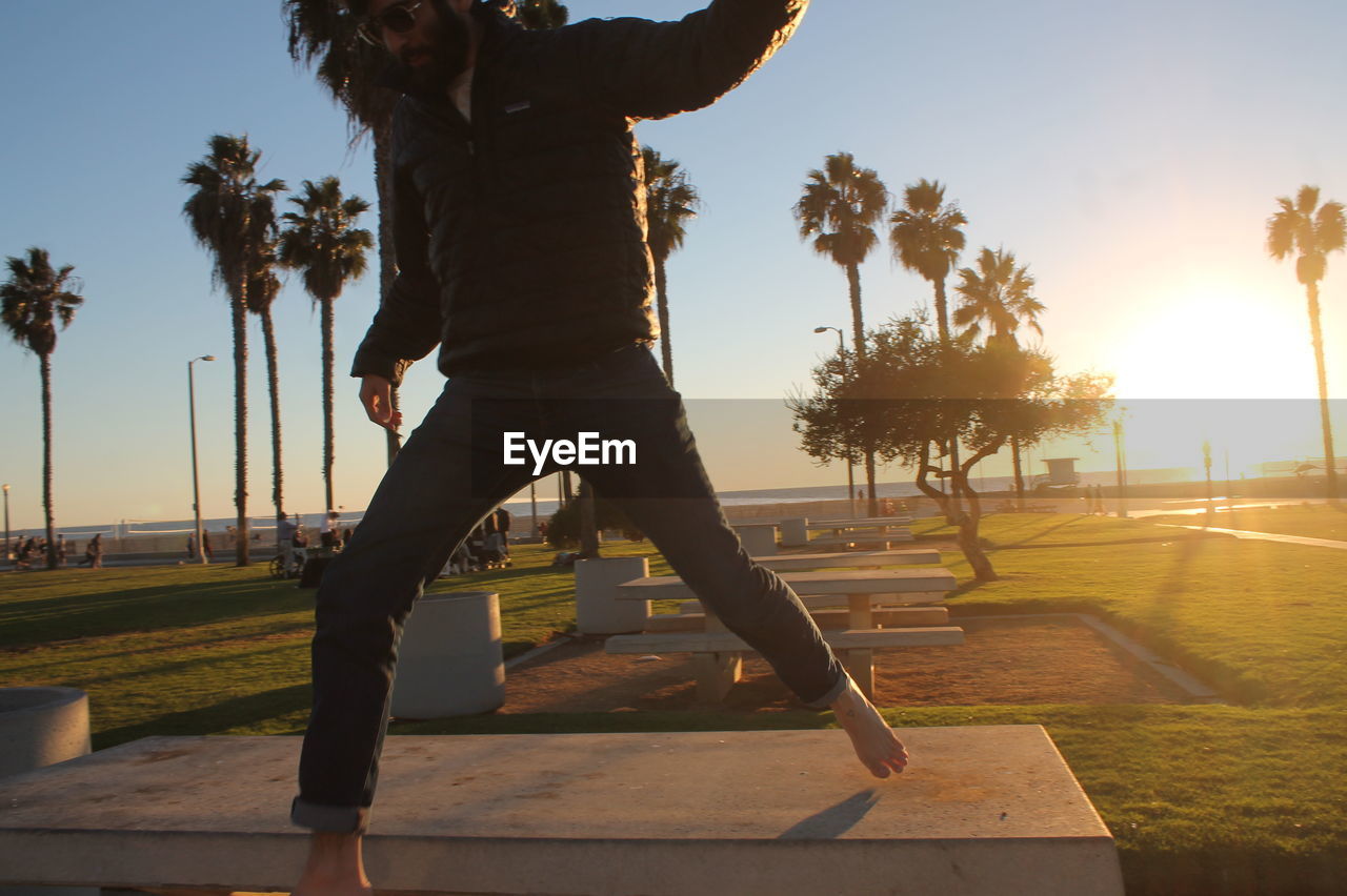 Man standing on bench in park