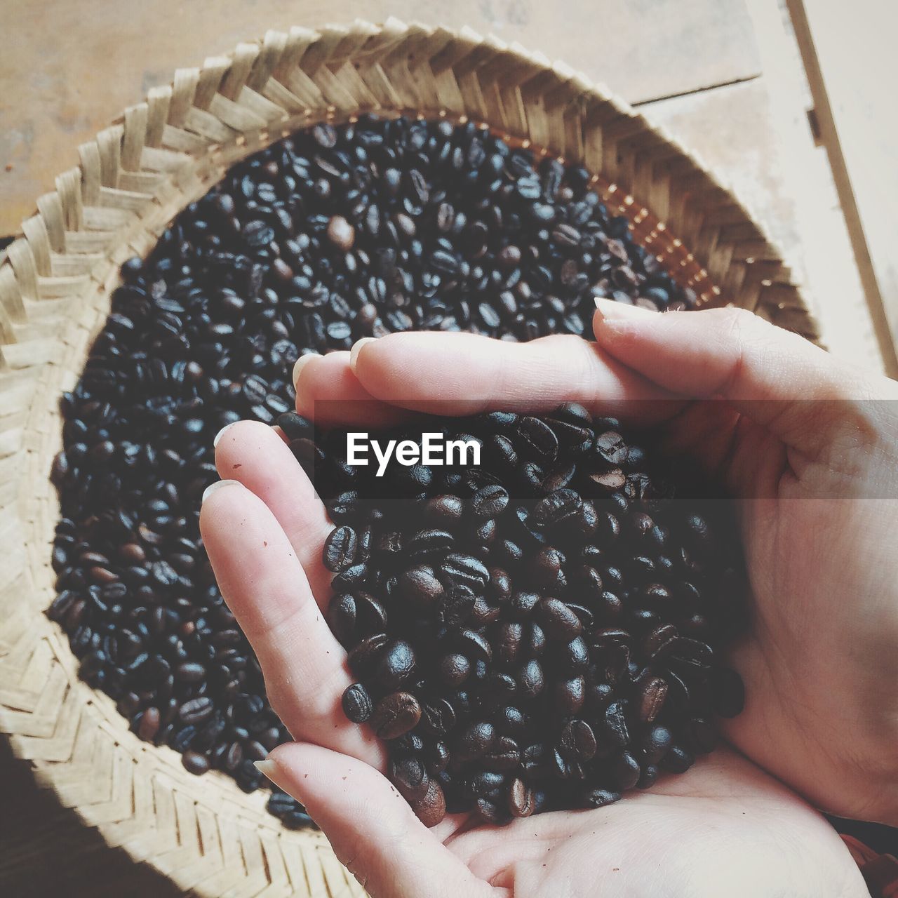 Cropped hands of person holding roasted coffee beans