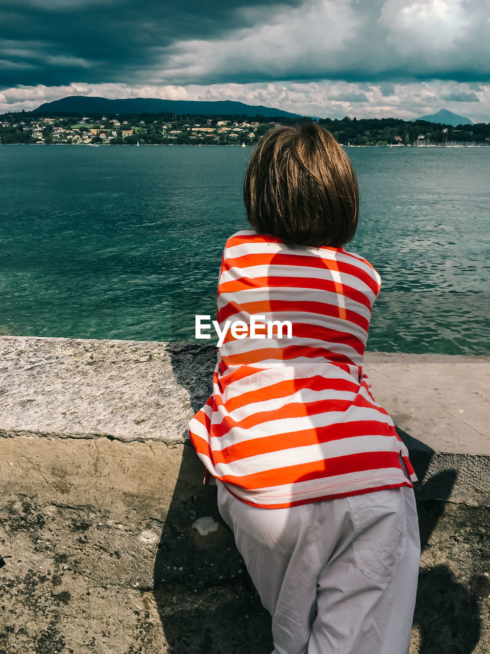 Rear view of boy looking at lake