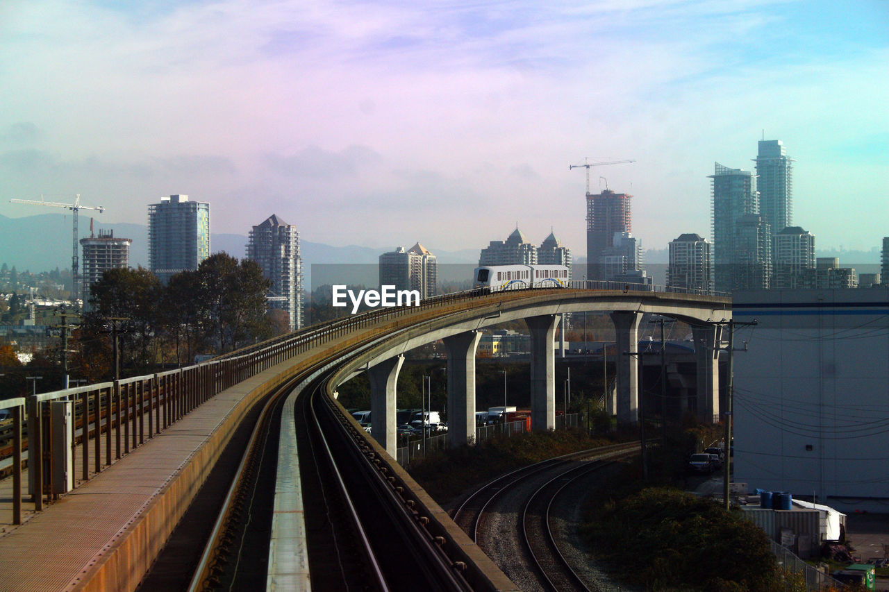 RAILROAD TRACKS WITH CITY IN BACKGROUND