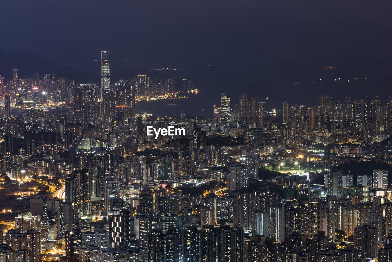 Illuminated cityscape against sky at night