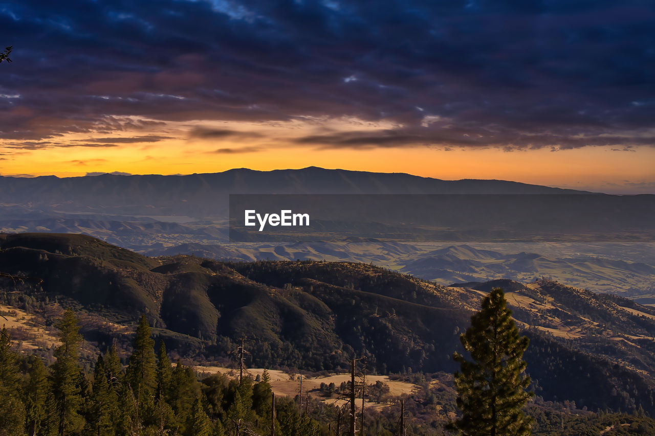 SCENIC VIEW OF MOUNTAINS AGAINST ORANGE SKY