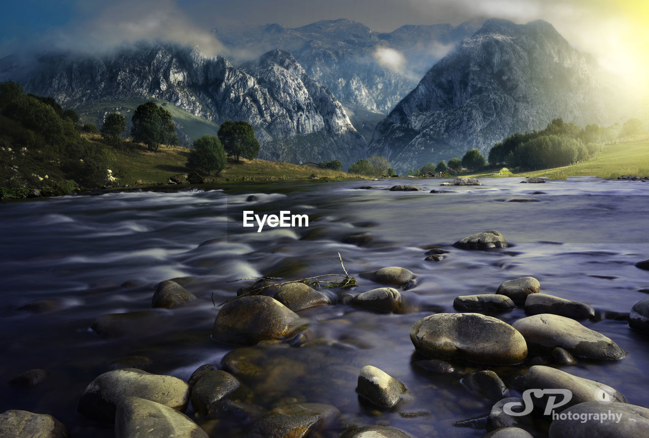 Scenic view of lake and rocks against sky