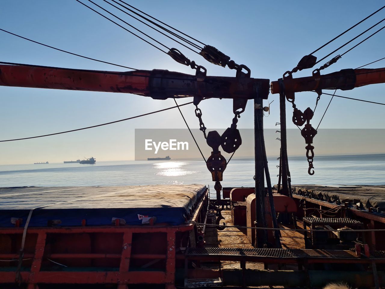 CRANES AGAINST SKY AT SEA