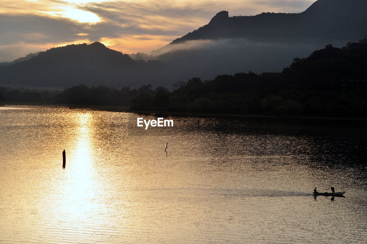 Scenic view of lake against sky during sunrise