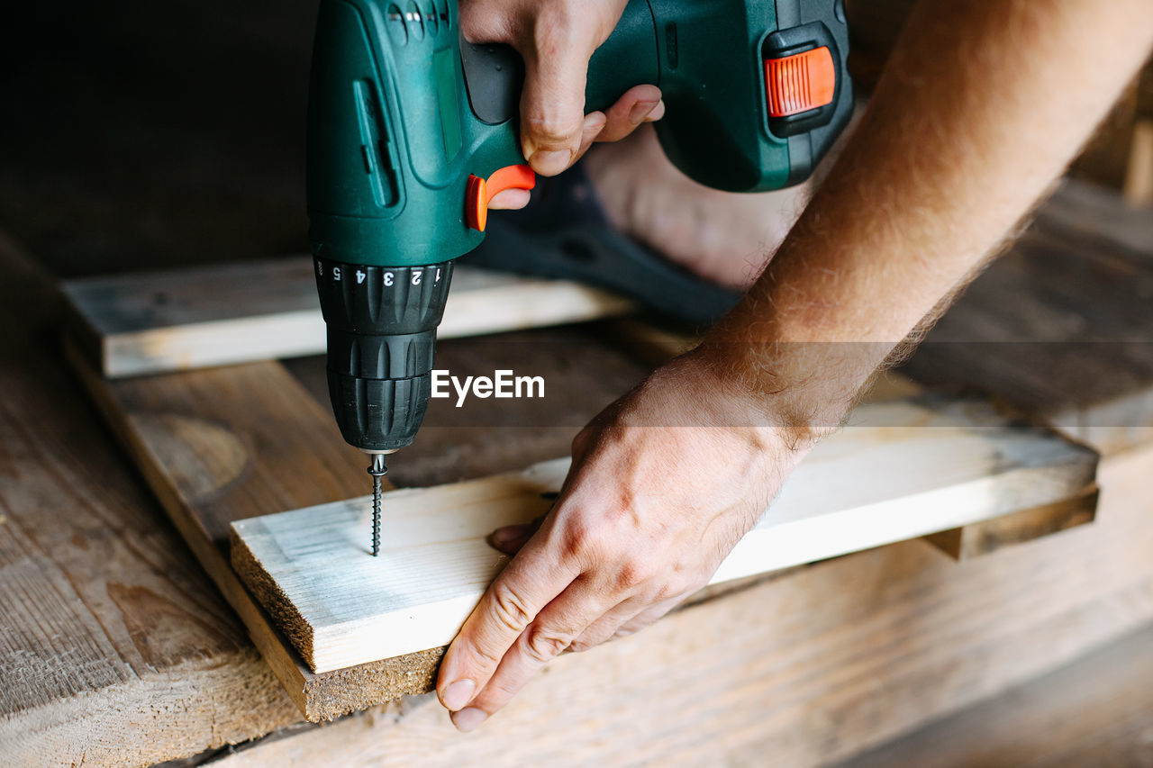 Work with a screwdriver. sewing together wooden block with a screw