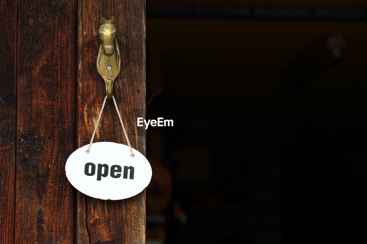 Close-up of information sign on wooden door