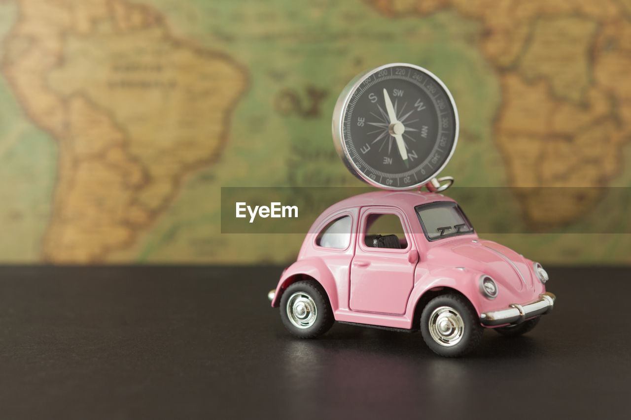 Close-up of toy car and navigational compass on table