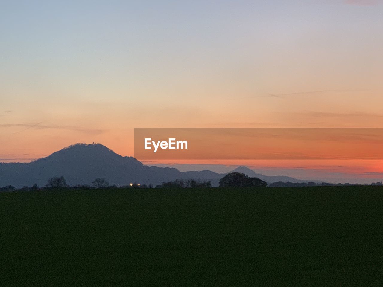 Scenic view of field against sky during sunset