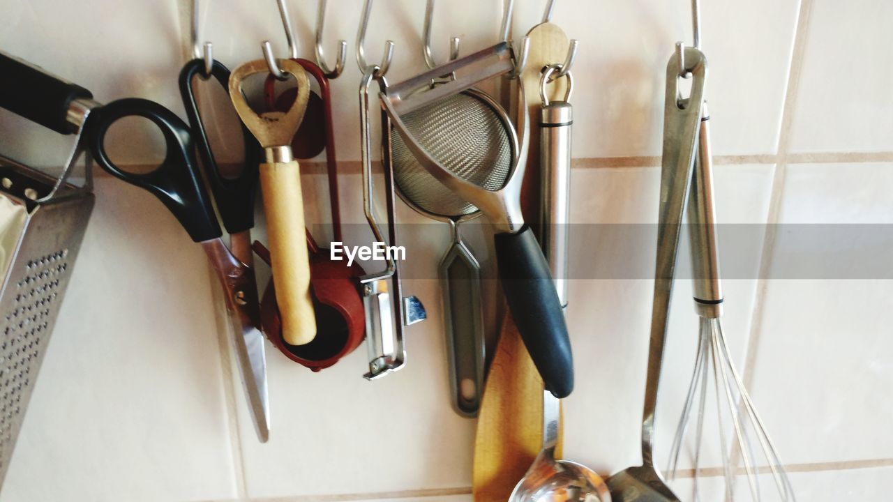 Close-up of kitchen utensils hanging on wall