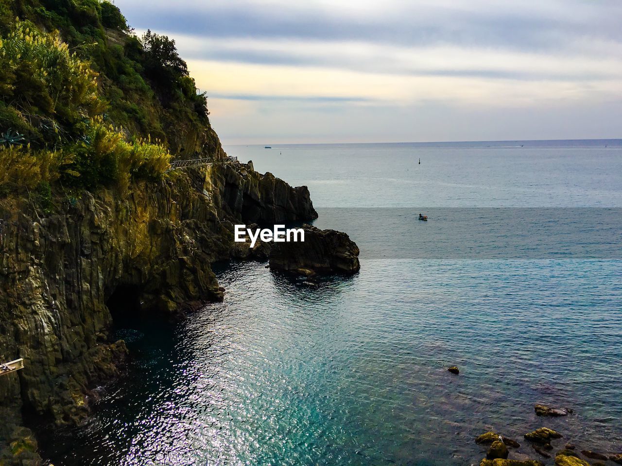 Scenic view of mountain by sea against sky