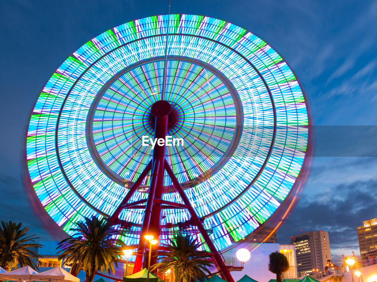Beautiful ferris wheel spinning long exposure neons in night.