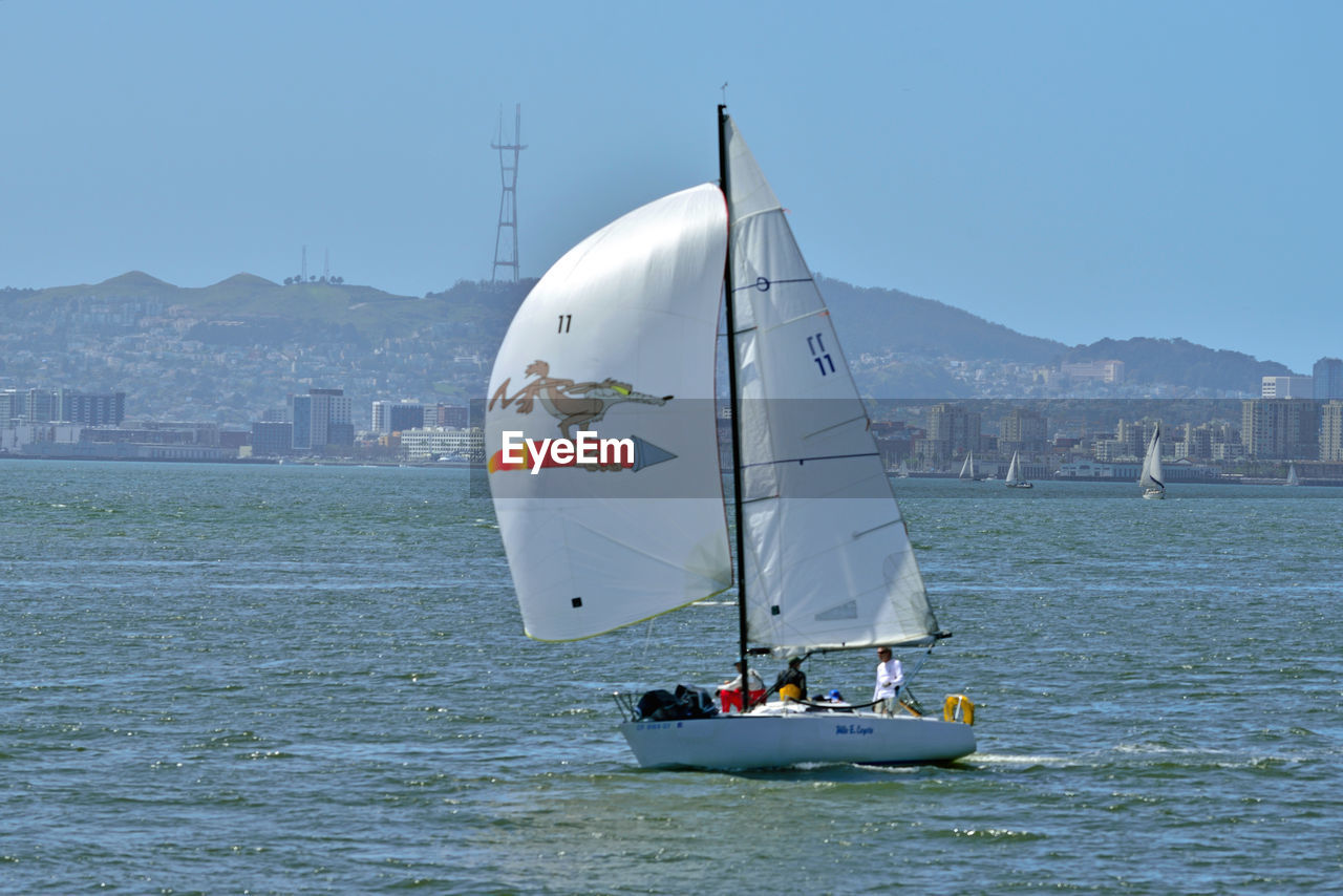 SAILBOAT SAILING ON SEA AGAINST SKY