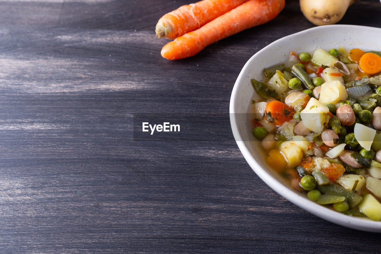 food and drink, food, healthy eating, vegetable, wellbeing, freshness, carrot, root vegetable, bowl, vegetarian food, produce, dish, wood, no people, fruit, baby carrot, salad, high angle view, table, indoors, onion, raw food, studio shot, still life, ingredient, organic, copy space, meal