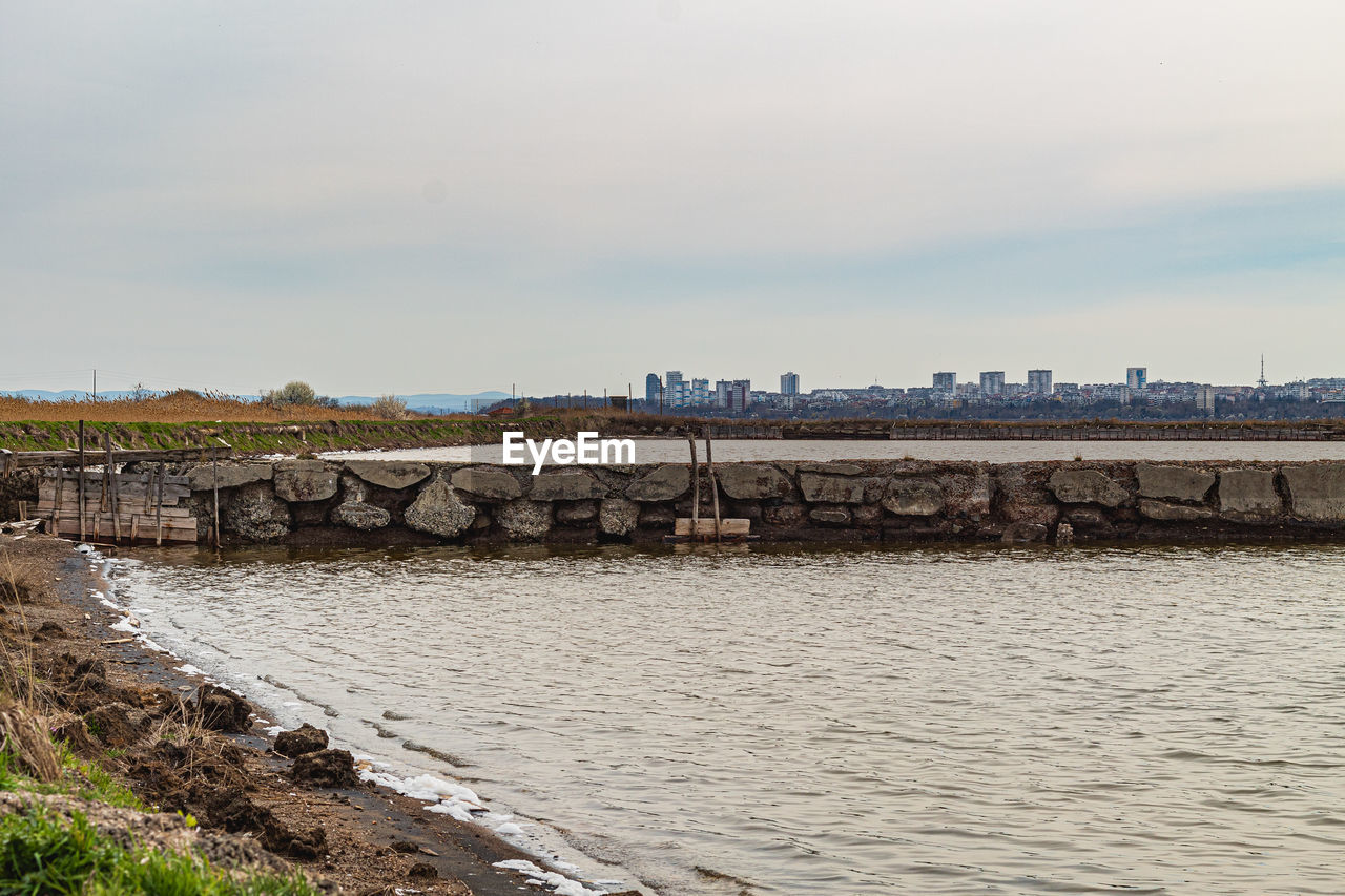 WALL BY RIVER AGAINST SKY