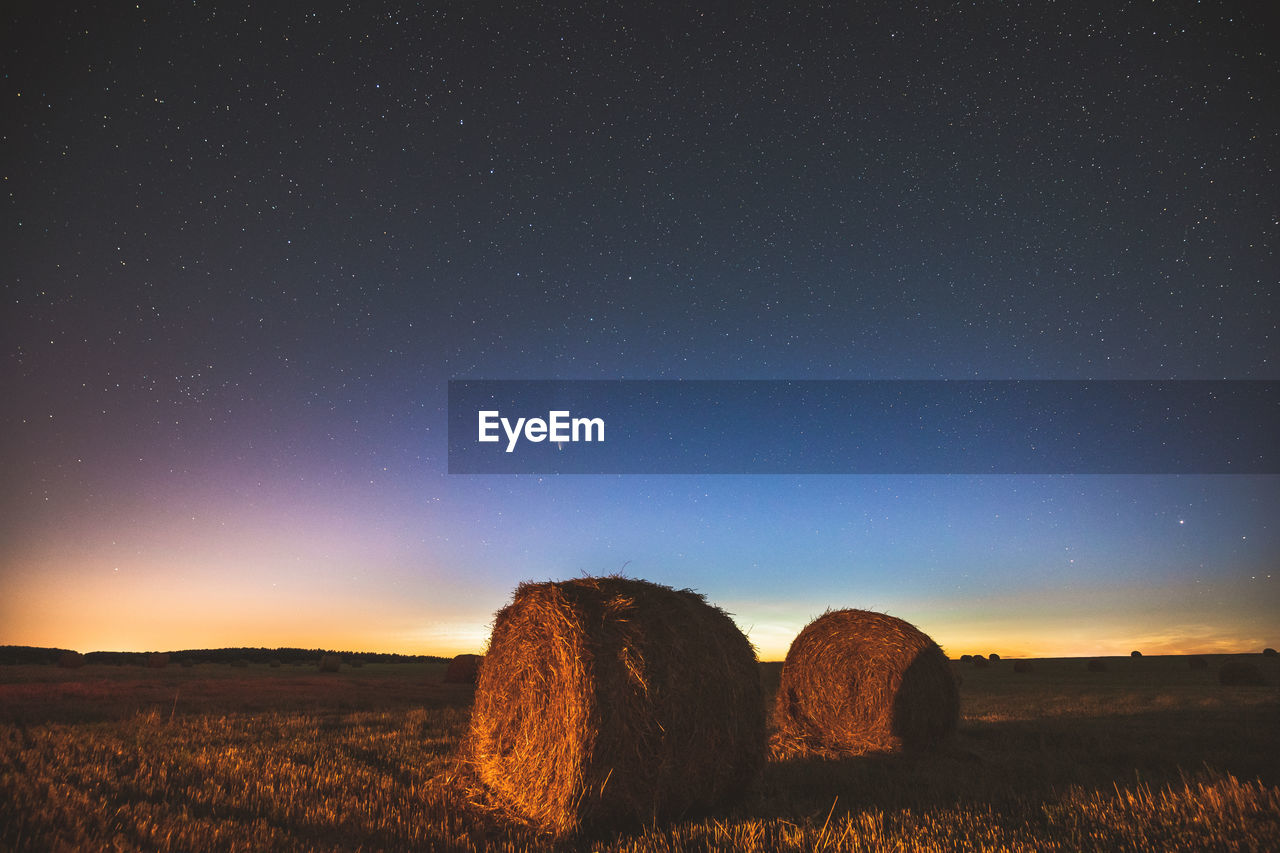 HAY BALES ON FIELD AGAINST SKY