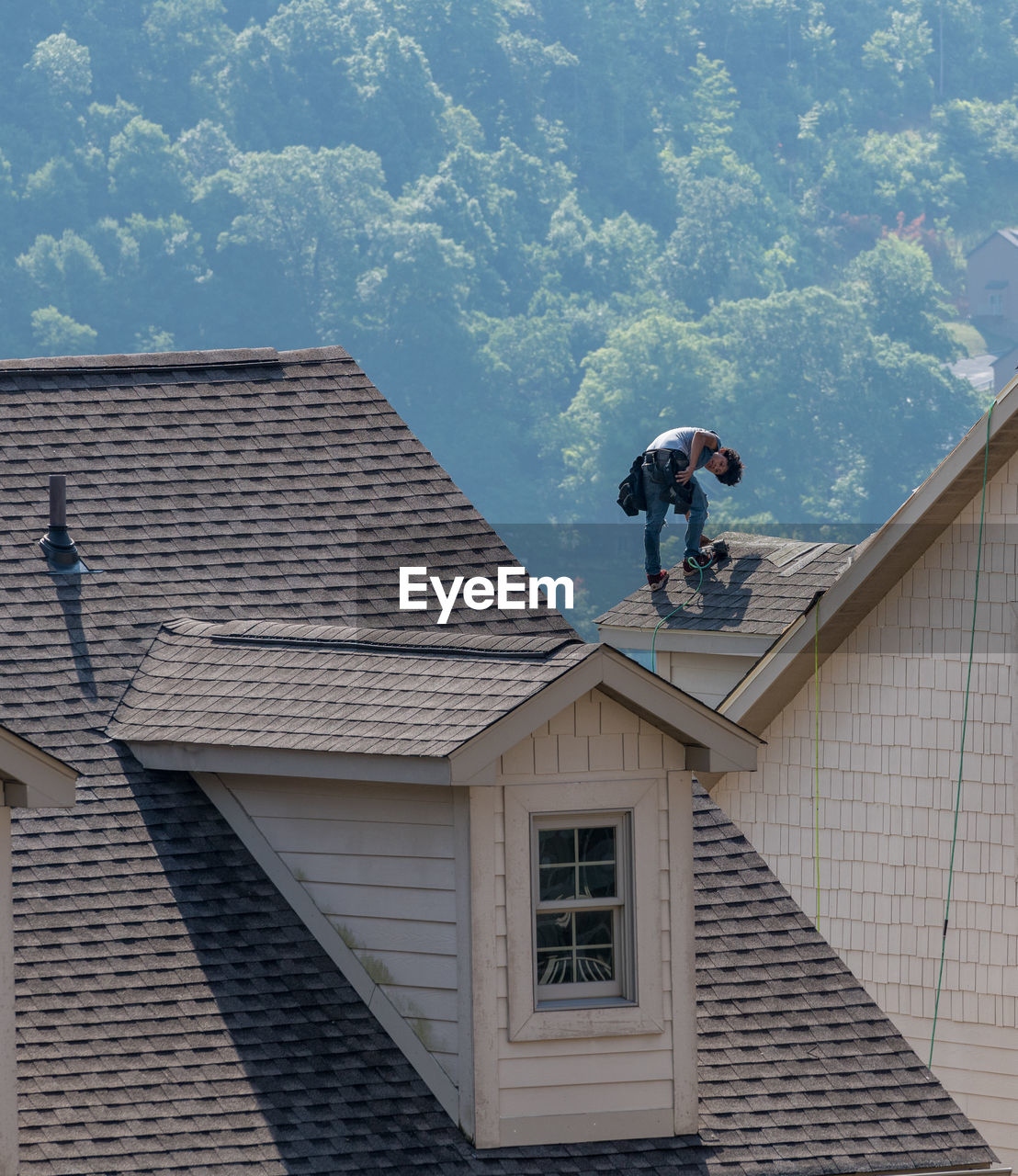 REAR VIEW OF MAN STANDING OUTSIDE HOUSE