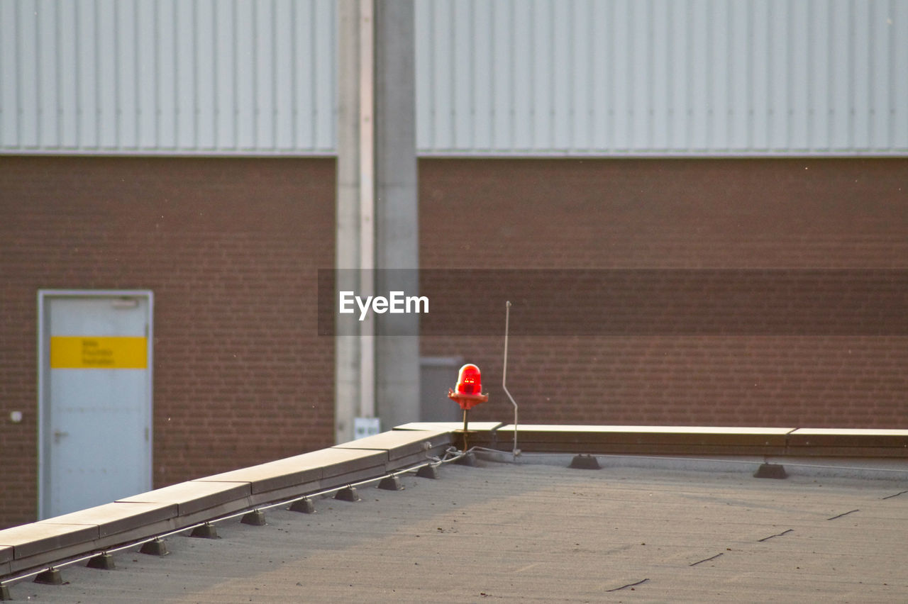 Rear view of safety lamp on rooftop against building