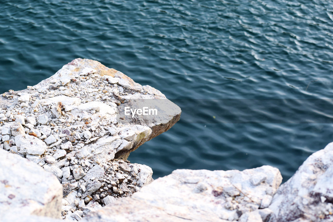water, rock, sea, day, nature, shore, no people, beauty in nature, high angle view, tranquility, ocean, outdoors, coast, scenics - nature, wave, tranquil scene, rock formation, sunlight, rippled, beach