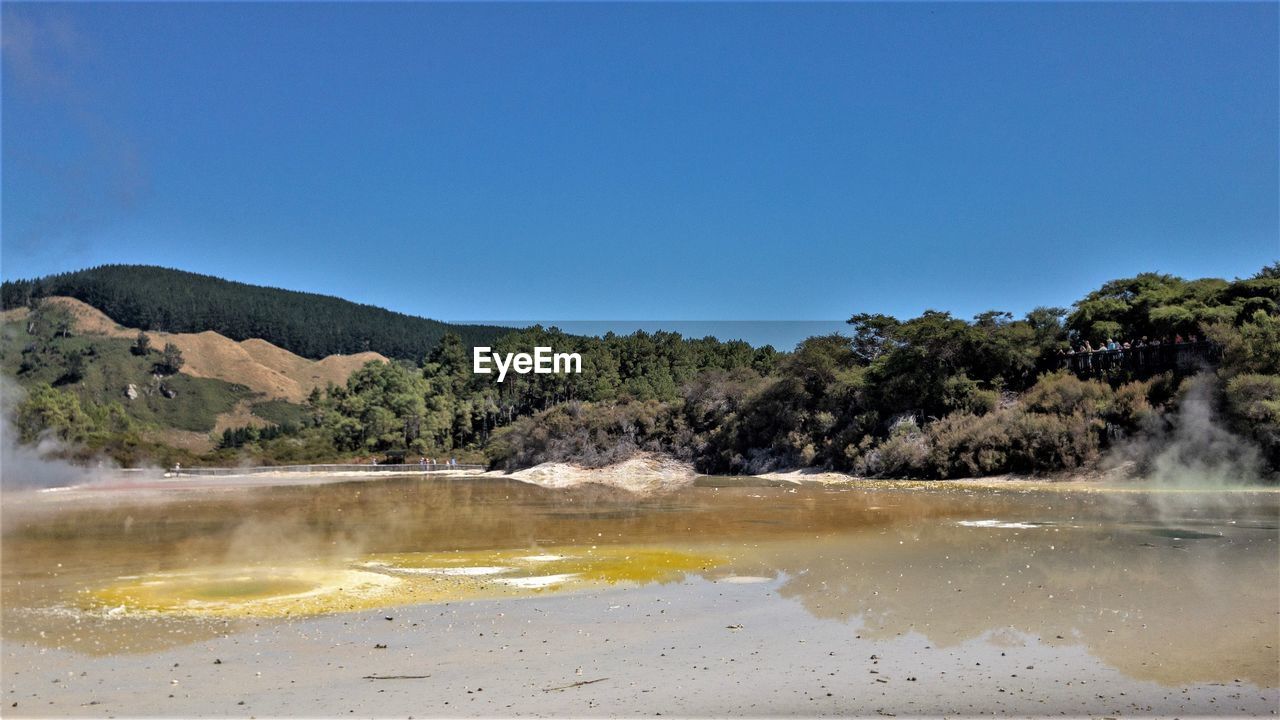 Scenic view of lake against clear blue sky