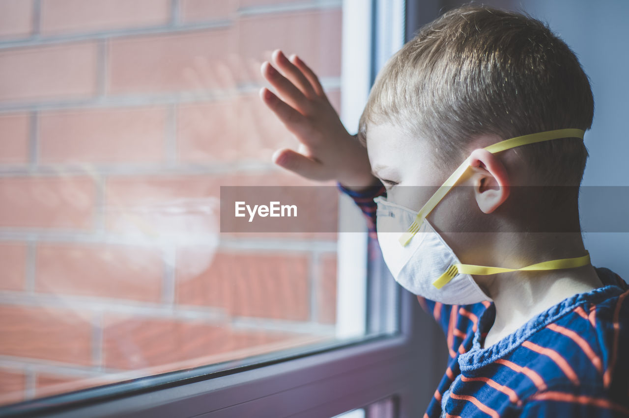 Portrait of boy looking through window